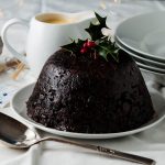 Christmas pudding decorated with holly and berries.