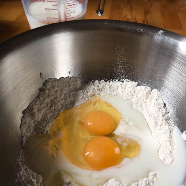 flour eggs and a little milk in bowl.