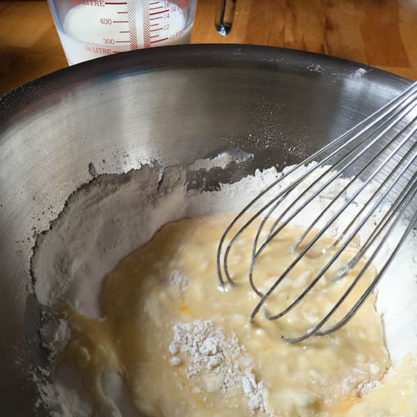 whisk in bowl starting to mix in the flour.