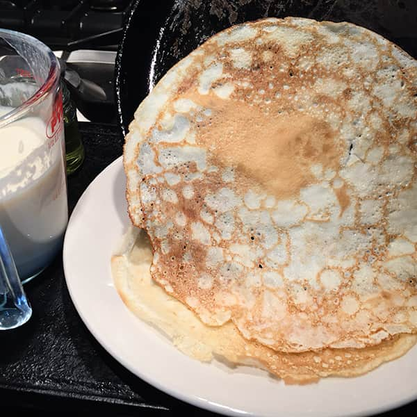 tipping pancake onto a plate.