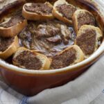 beef carbonnade in casserole topped with mustard croutes