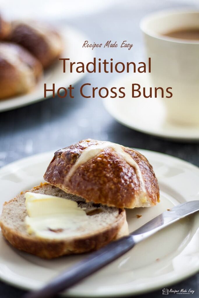 buttered hot cross bun on plate.