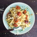 tagliatelle with tomatoes and garlic crumbs on a dinner plate with fork.