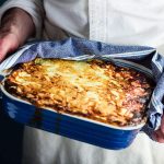 person holding dish of easy lasagne.