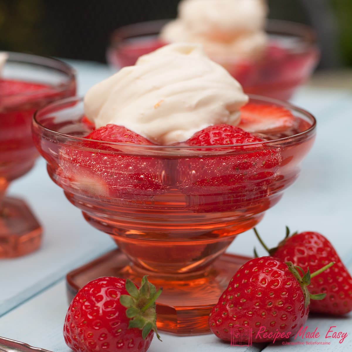 strawberry jelly in glass dish topped with Chantilly cream.