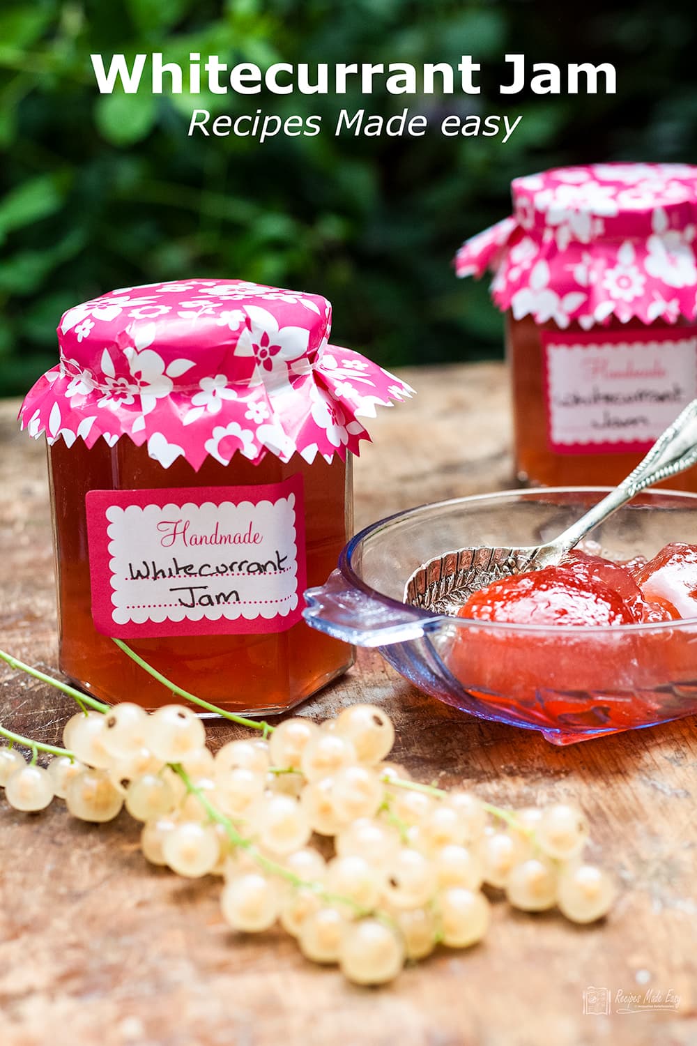 2 jars of whitecurrant jam with some jam in a glass bowl and fresh whitecurrants in front.