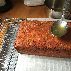 spooning syrup over cake.