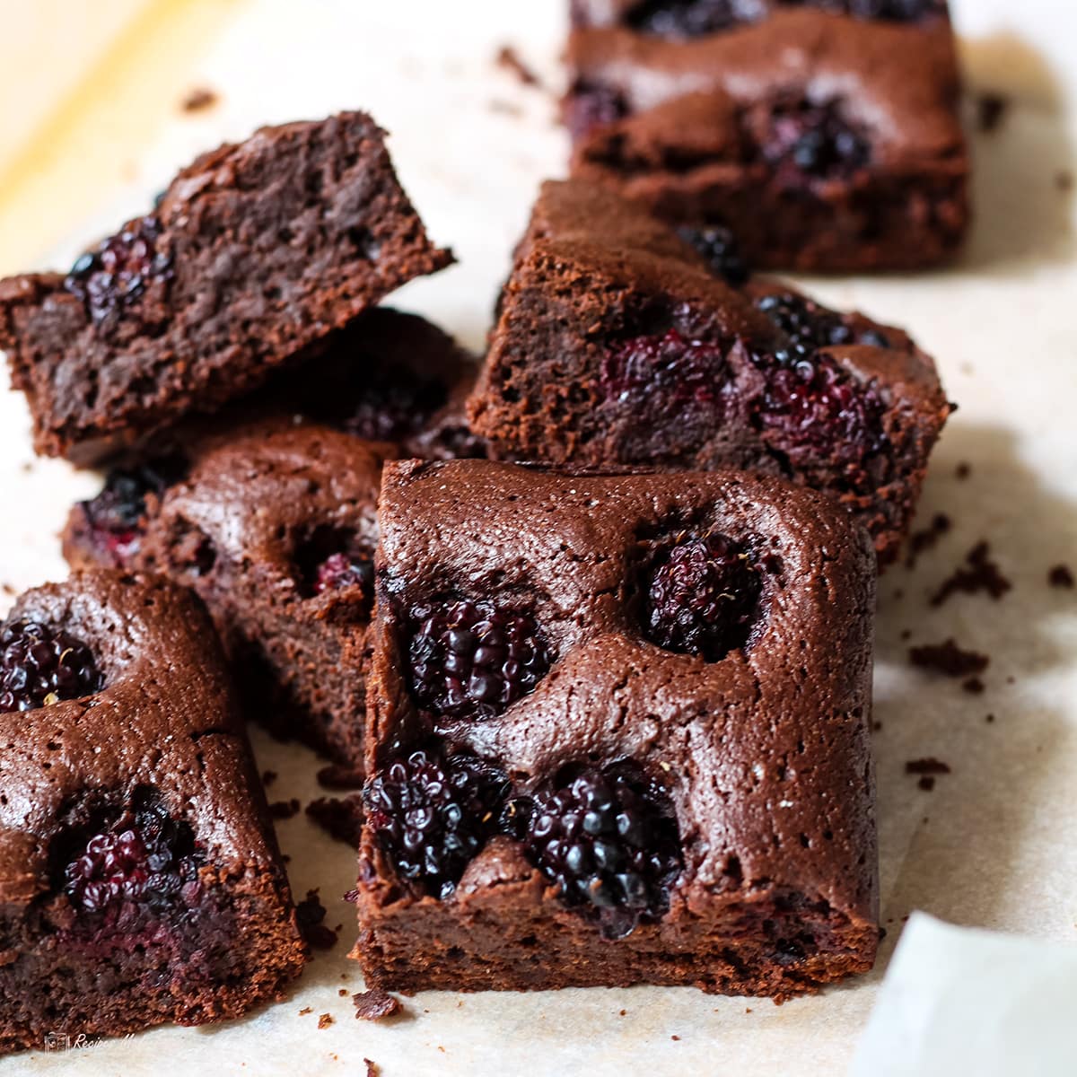 blackberry brownies on parchment.