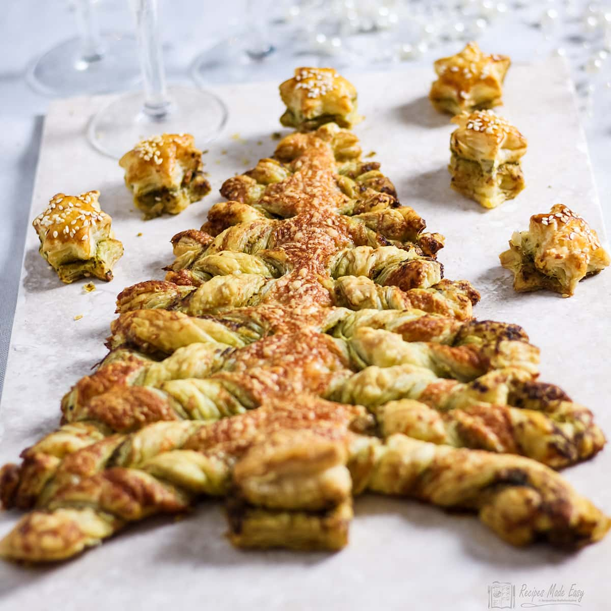 Easy pesto Christmas tree on a tile with pastry stars around the top.