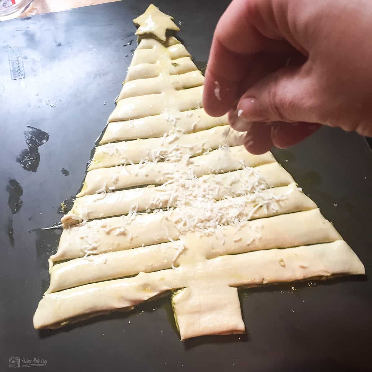 sprinkling the tree with parmesan.