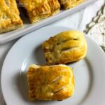 Two pork and cranberry sausage rolls on a tea plate.