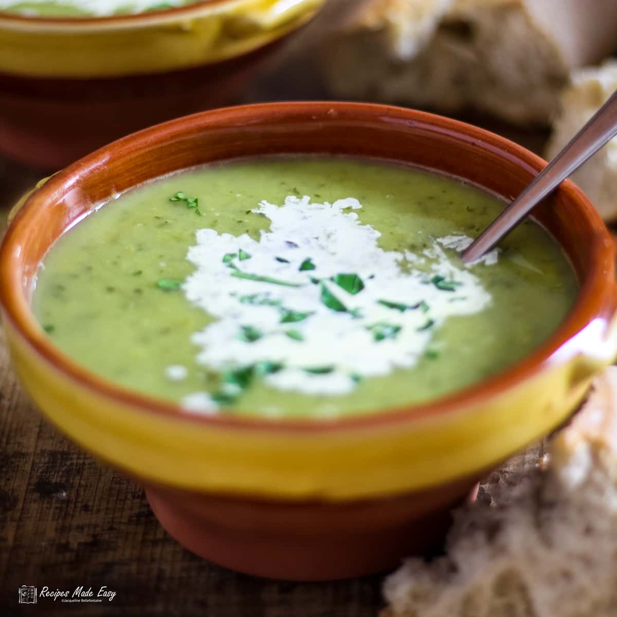 bowl of pea and watercress soup with spoon in bowl.