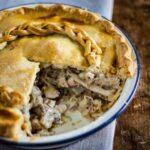 chicken and mushroom pie with portion removed showing filling.