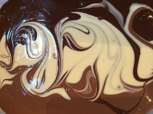 Tap the baking sheet to level out the chocolate. Tap the baking sheet to level out the chocolate.