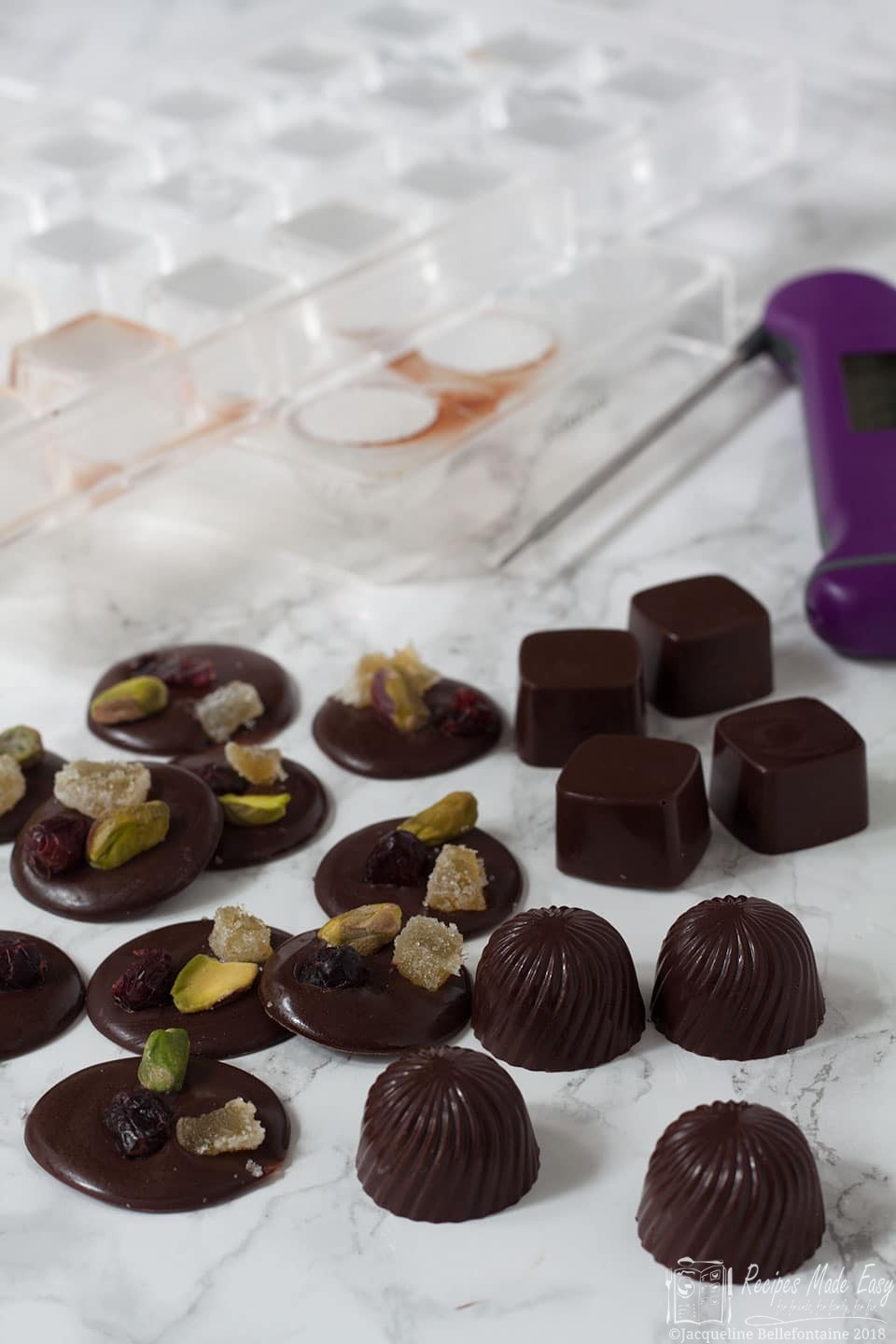 Selection of homemade chocolates by recipes made easy with chocolate moulds and thermometer on the side