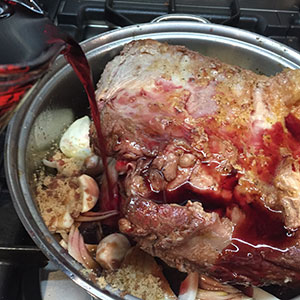 Pour in the red wine and stock. Braised beef short ribs - adding wine and stock