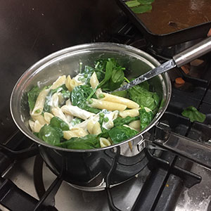 Toss until combined. mixingtogther all the ingredients for penne with peas and spinach by recipesmadeeasy.co.uk