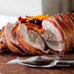 sliced stuffed pork tenderloin on a chopping board.