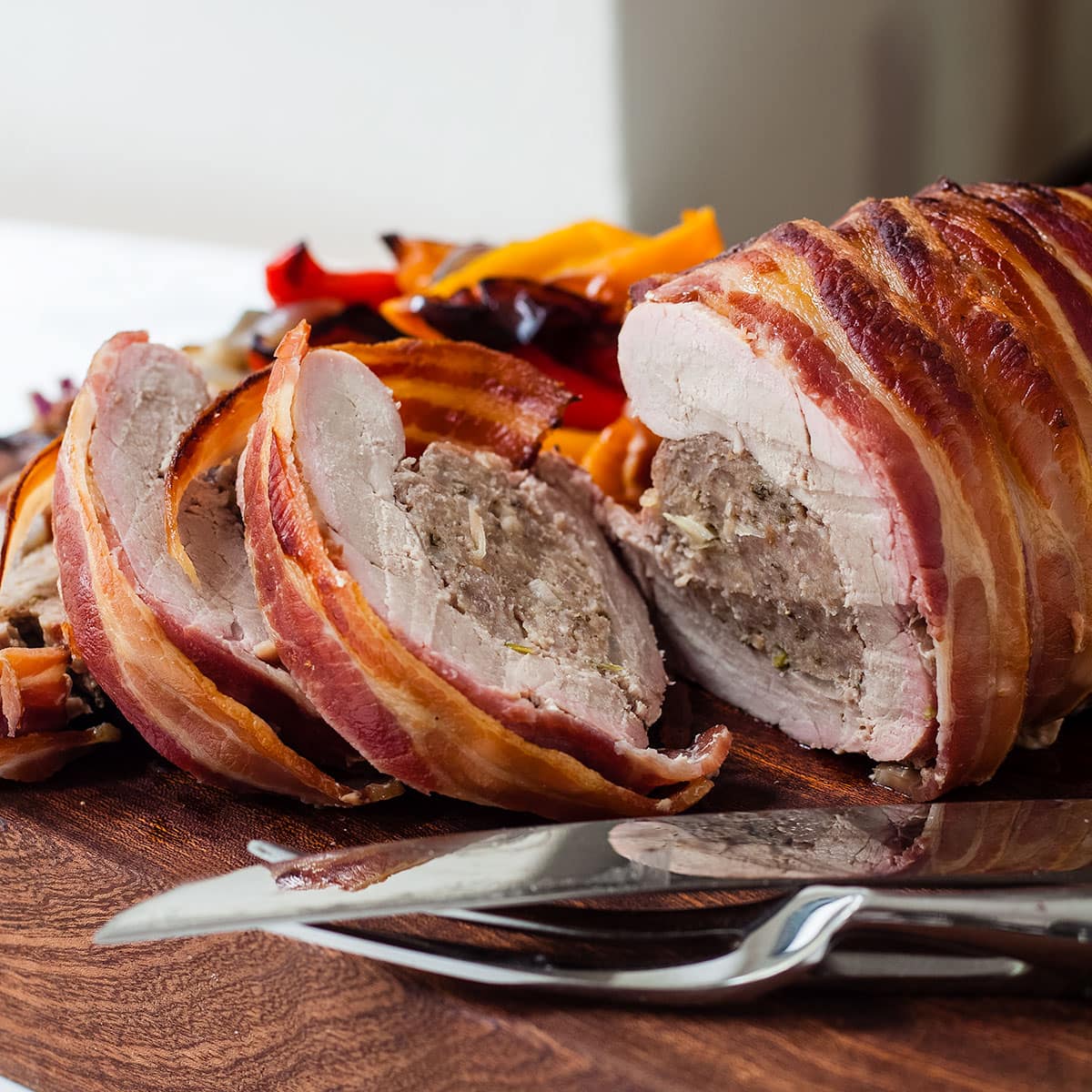 sliced stuffed pork tenderloin on a chopping board.