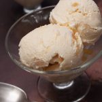 2 scoops of stem ginger ice cream in a bowl with second bowl in top corner.