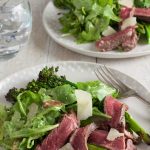 Plate of chargrilled broccoli, rocket and beeg salad by recipe made easy with second plate in back ground