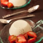 Two plates of basil panna cotta with balsamic strawberries by Recipes Made Easy.