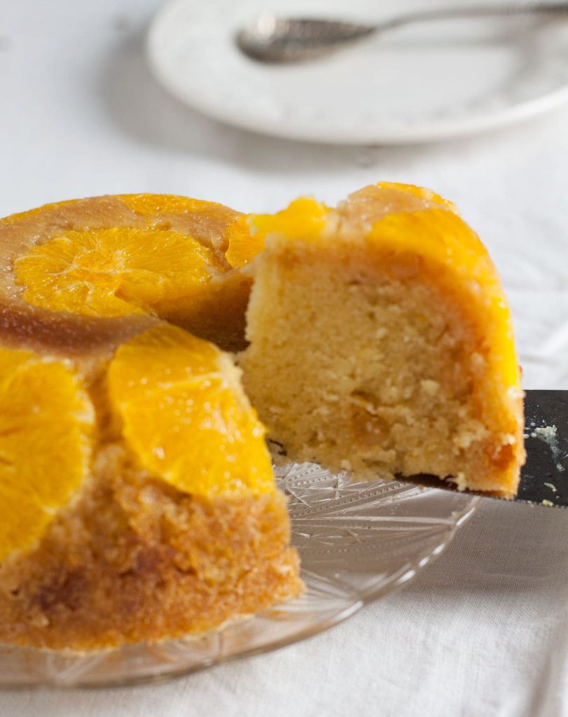 orange and stem ginger pudding with a slice being taken from it. Recipes Made Easy