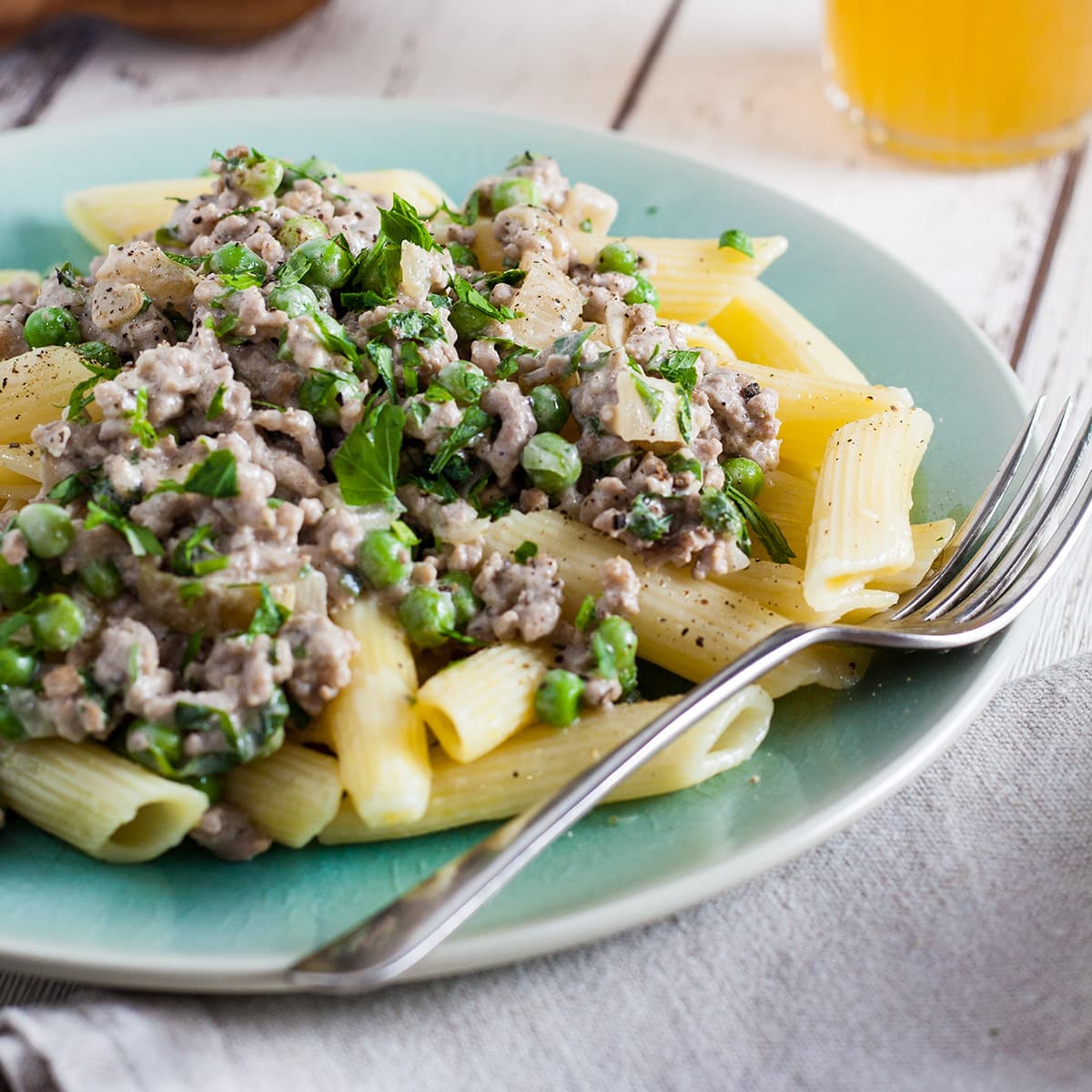 plate of pasta with creamy pork and peas.