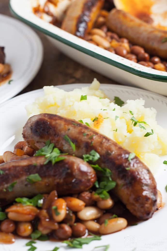 Sausages with easy homemade baked beans on a plate with mashed potatoes