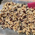 almond and cranberry mixture spread out on baking sheet