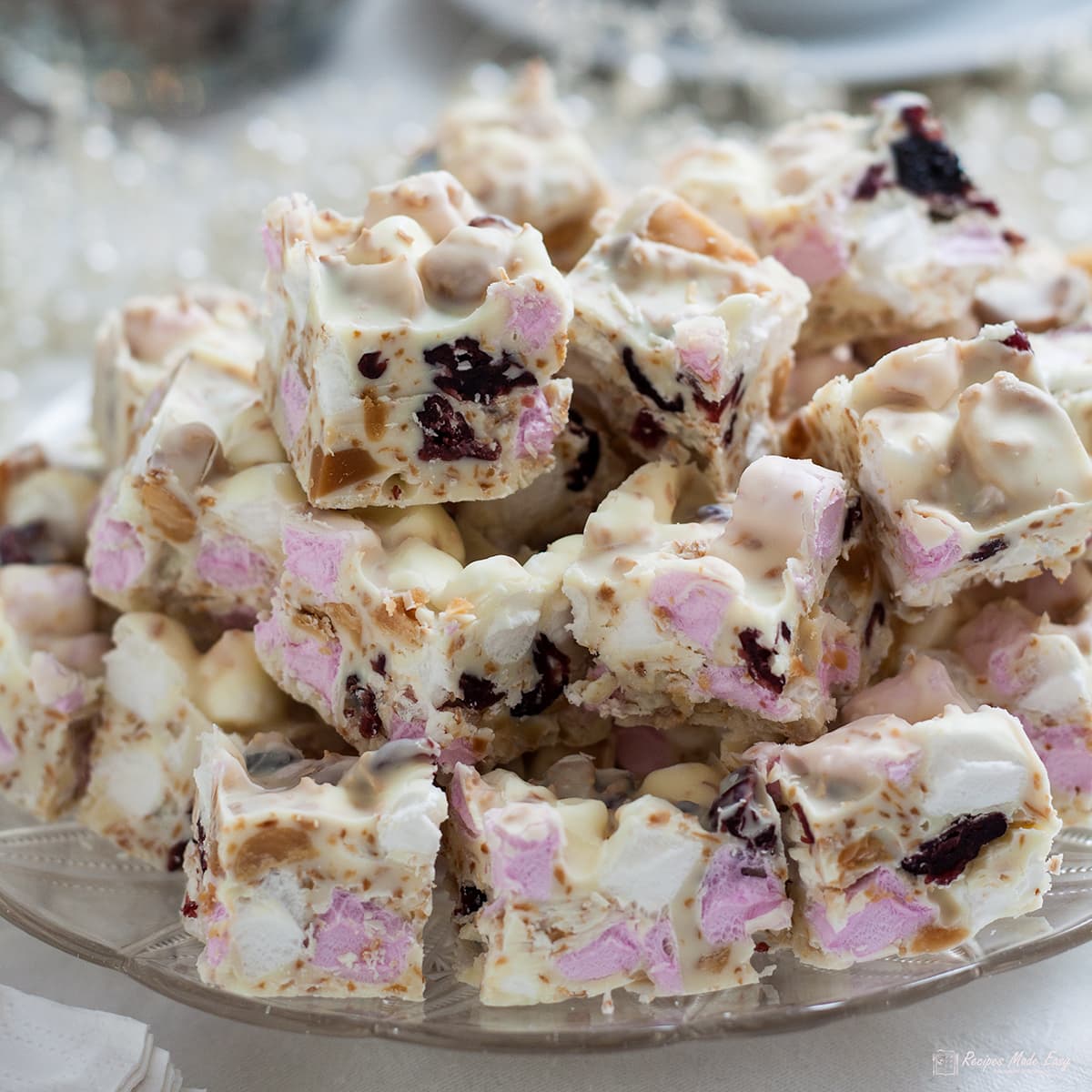 white christmas rocky road cut into pieces and piled onto a glass plate.