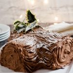 yule log on plate with stack of plates and napkins behind
