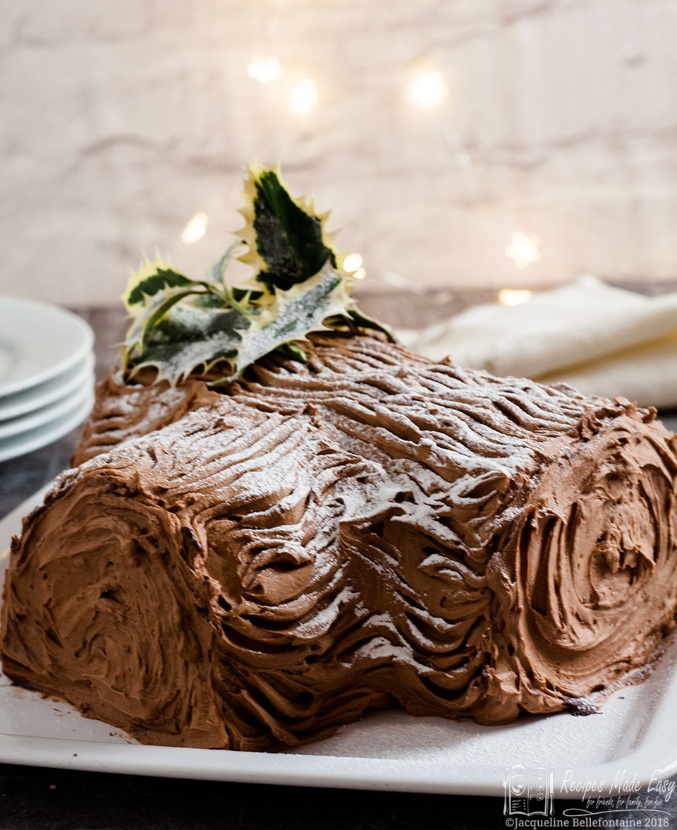 yule log on plate with stack of plates and napkins behind