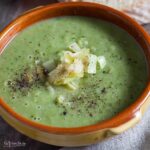 bowl of leek, spinach and cannellini bean soup with garnish of sauteed leeks and black pepper