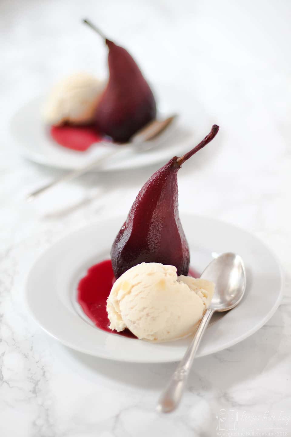 poached pear with ice cream on a plate