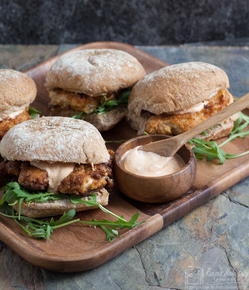 fried chicken sandwiches on board with a bowl of dip