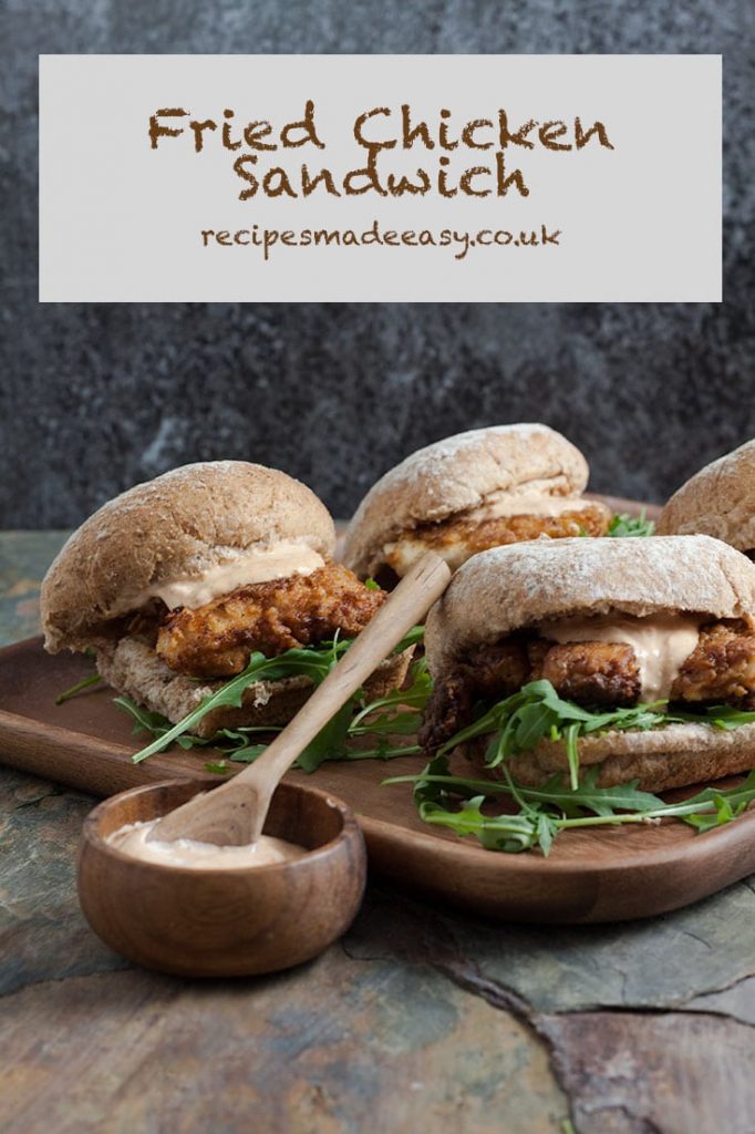 fried chicken sandwiches on board with bowl of dip in front