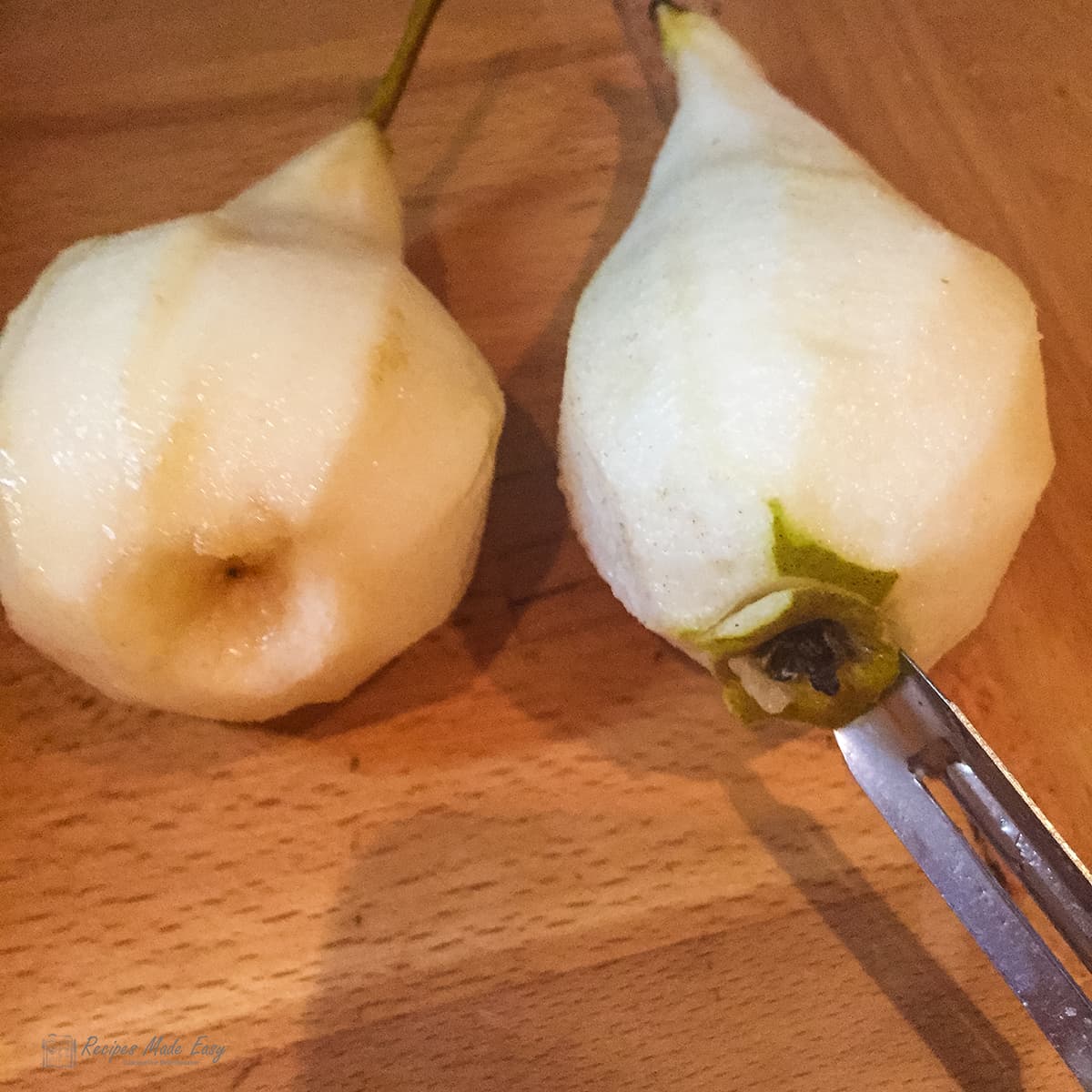 Removing core from base of peeled pear.