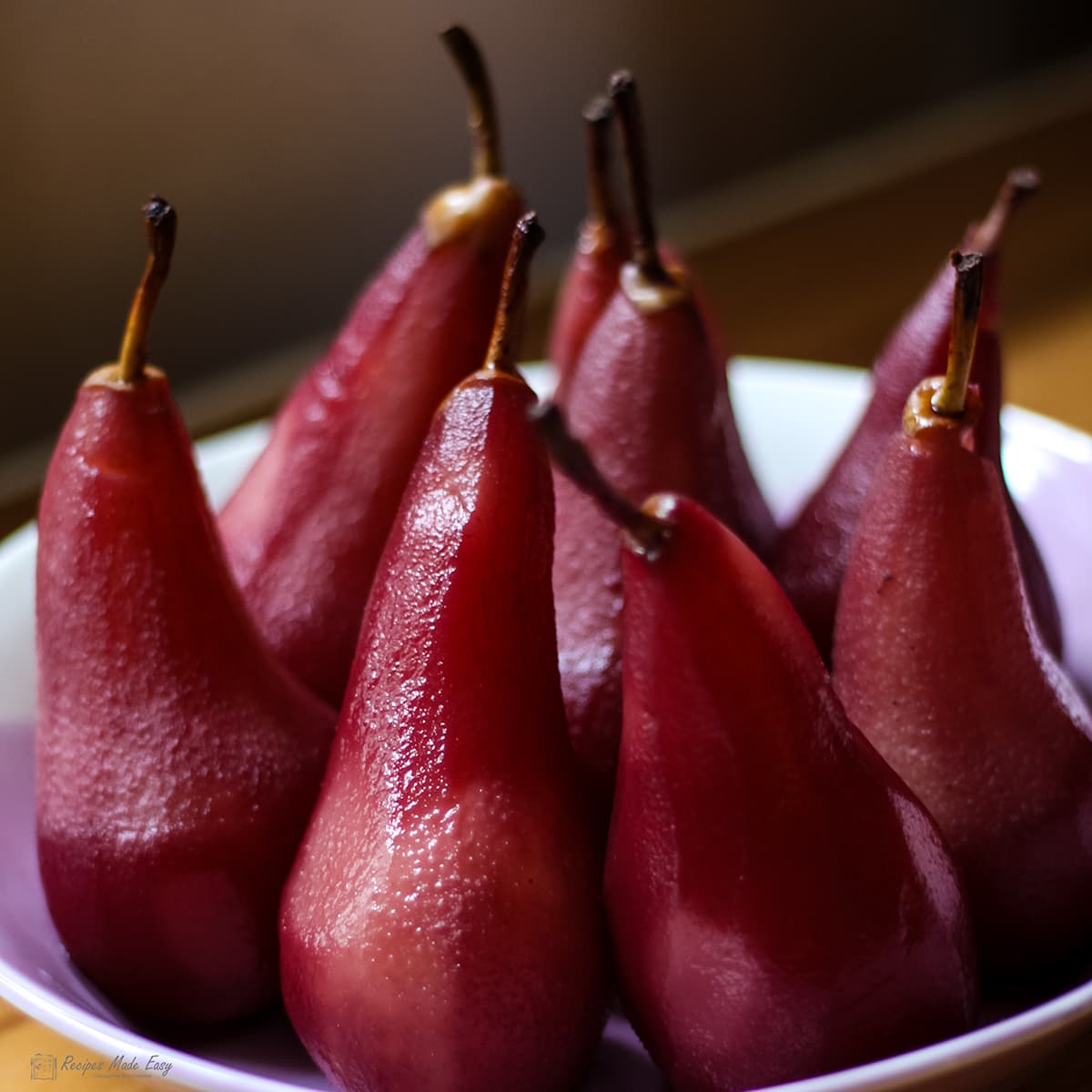 Pears poached in red wine standing in a bowl