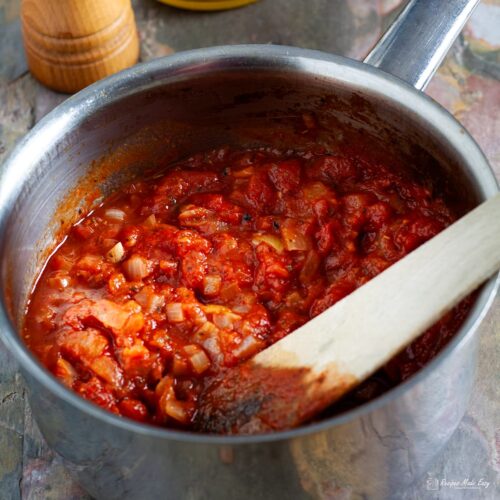 saucepan of really easy tomato sauce with wooden spatula for stirring.