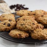 oat and raisin cookies on a wire plate with pats and raisins in the background
