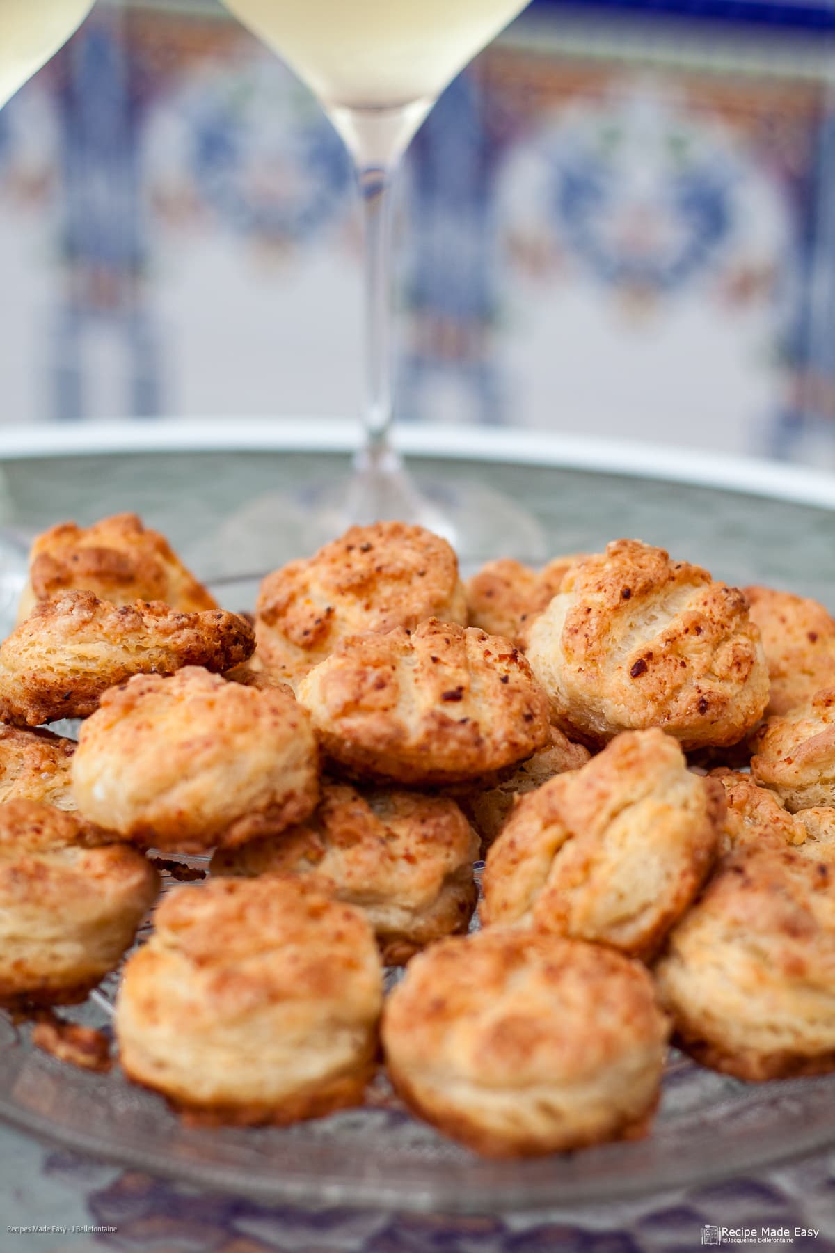Pog&aacute;csa on a plate with glass of wine behind.