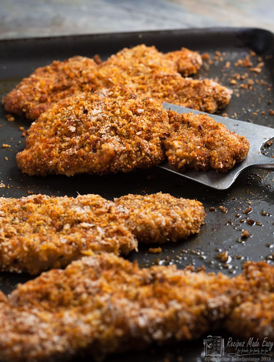 oven baked pork schnitzel on a baking sheet