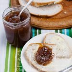 pot of easy rhubarb and elderflower jam next to a plate of bread and jam