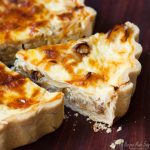 closeup on slice of onion tart on a board