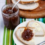 pot of easy rhubarb and elderflower jam next to a plate of bread and jam