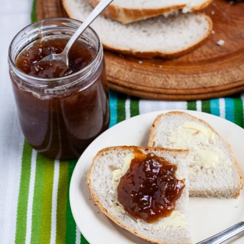 pot of easy rhubarb and elderflower jam next to a plate of bread and jam