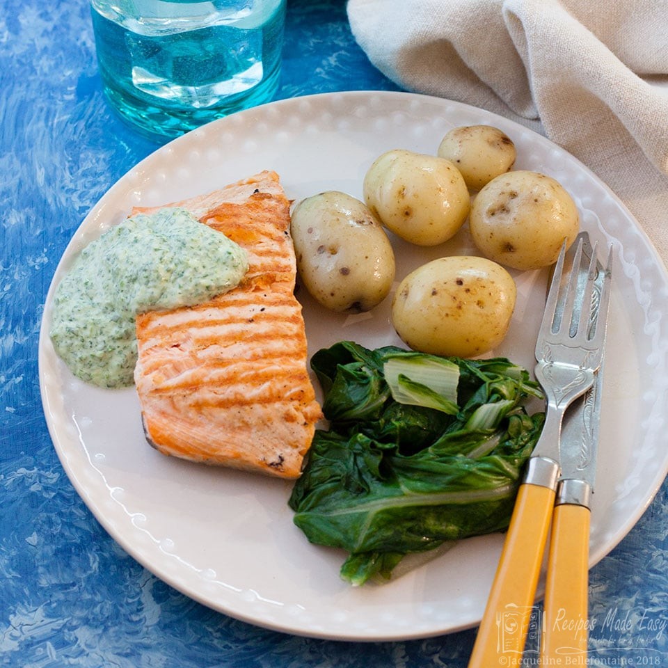 salmon with watercress sauce on a plate with vegetables