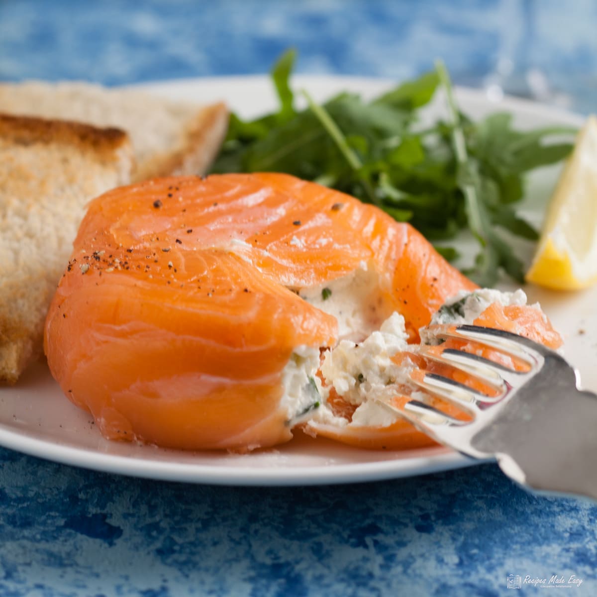 smoked salmon parcel opened with fork showing cream cheese filling.