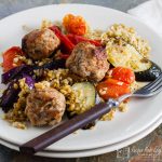 pork, lemon and thyme meatballs with roasted veg and freekeh on a serving plate